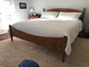 Low post bed with custom footboard in curly maple with aged maple finish