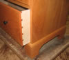 Dovetailed drawer with lipped drawer front, ebonized knob and mitered base